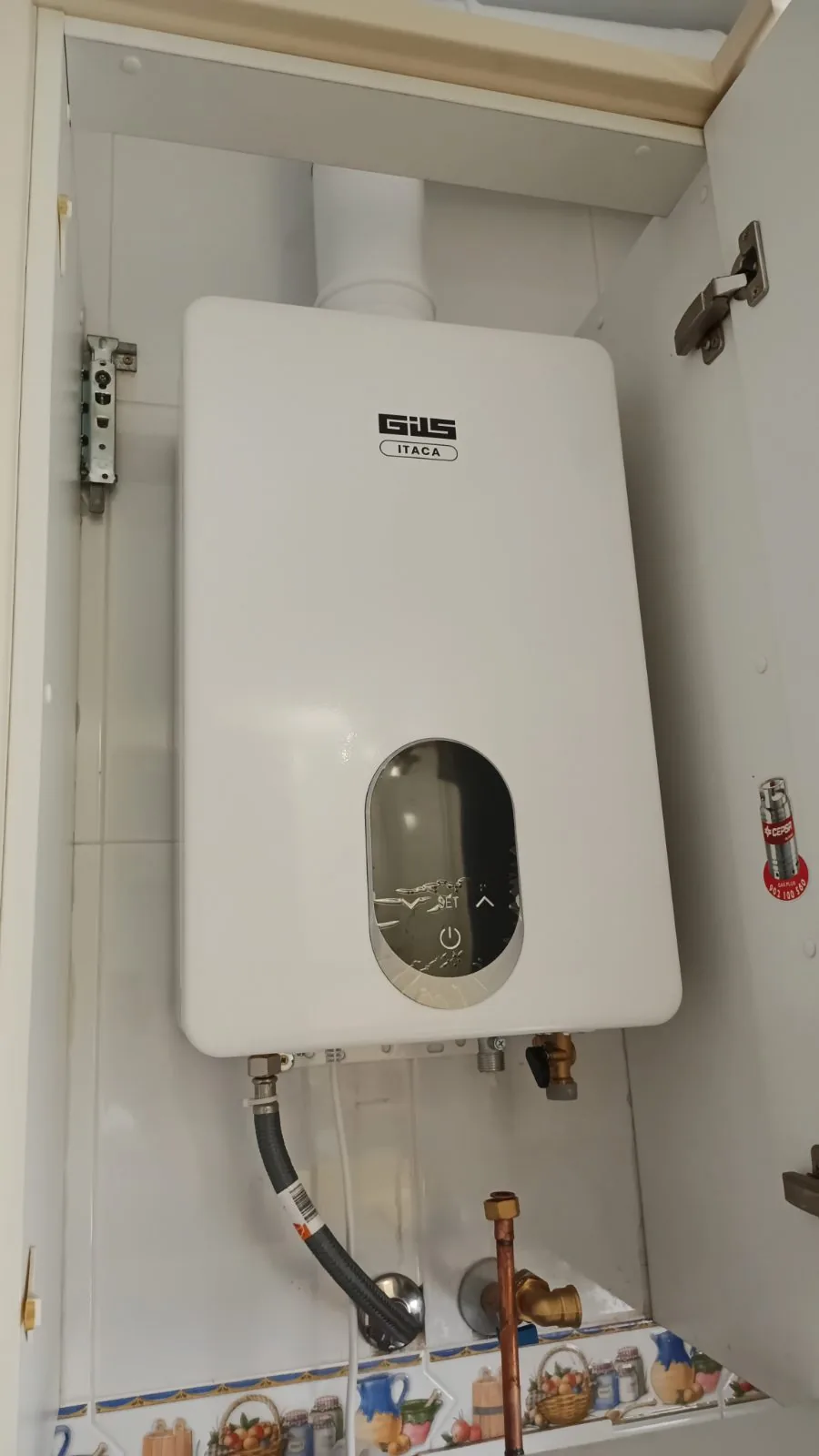 Calentador de gas instalado dentro de un armario con salida de humos y conexiones